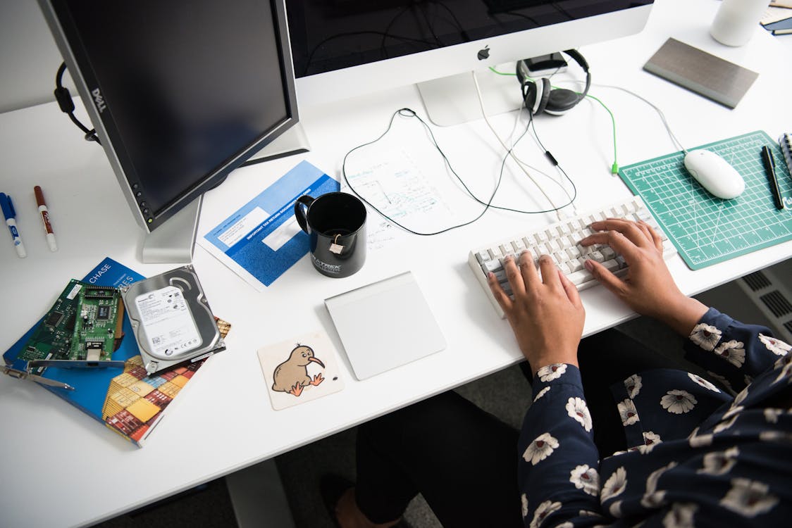 Person Typing On Corded Computer Keyboard Beside Apple Mighty Mouse