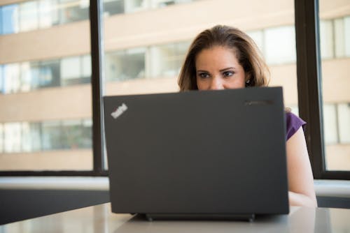 Woman Wearing Purple Top in Front of Lenovo Thinkpad