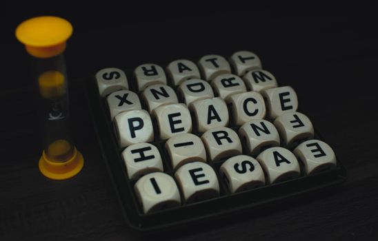 Lettered dice game with visible letters and a small timer on a dark surface.