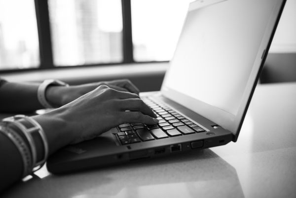 A writer at a laptop in an open-plan office — Christina Morillo on Pexels