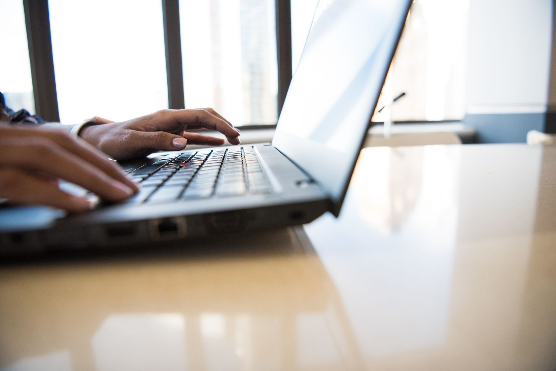 A person typing a reply on a laptop at a desk