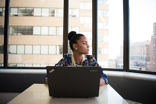 Woman Sits in Front of Black Laptop Computer