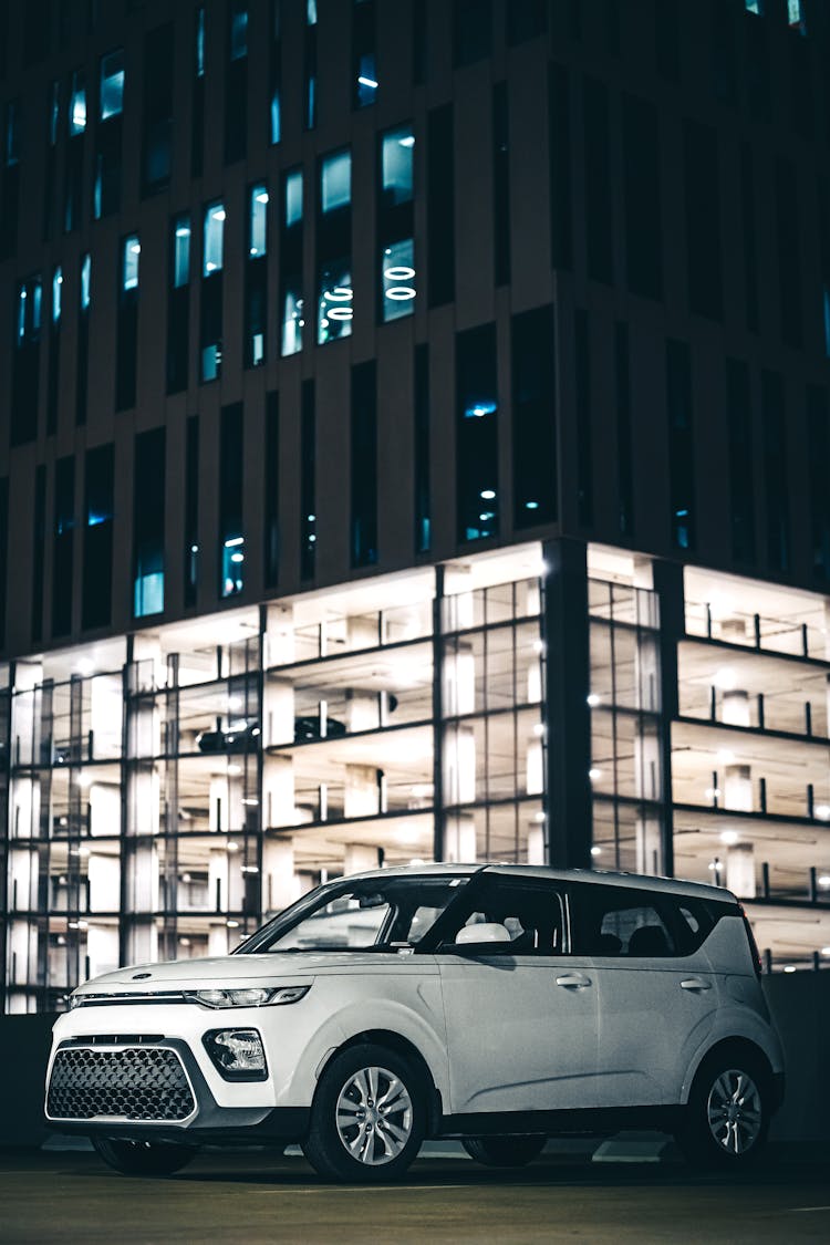 A White Car Parked Beside Concrete Building