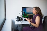 一位女士在办公室使用麦克风和笔记本电脑进行专业播客录音