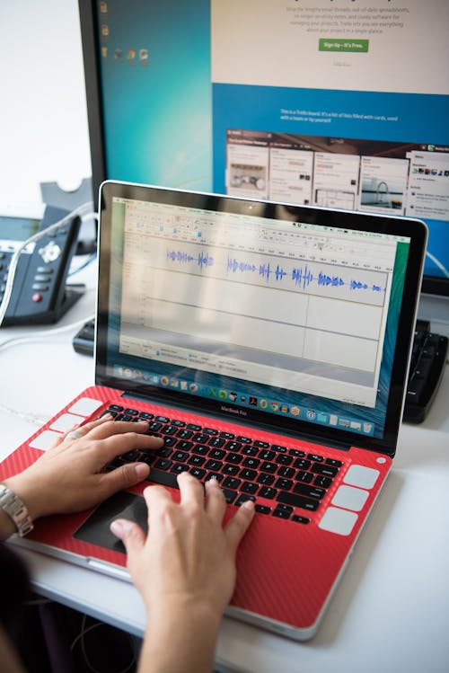 Person's Hands on Turned on Macbook Pro