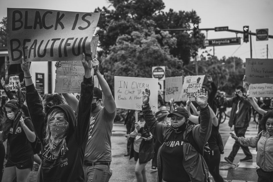 サインを持った多様な群衆が市街地で行う強力なBlack Lives Matterの抗議。