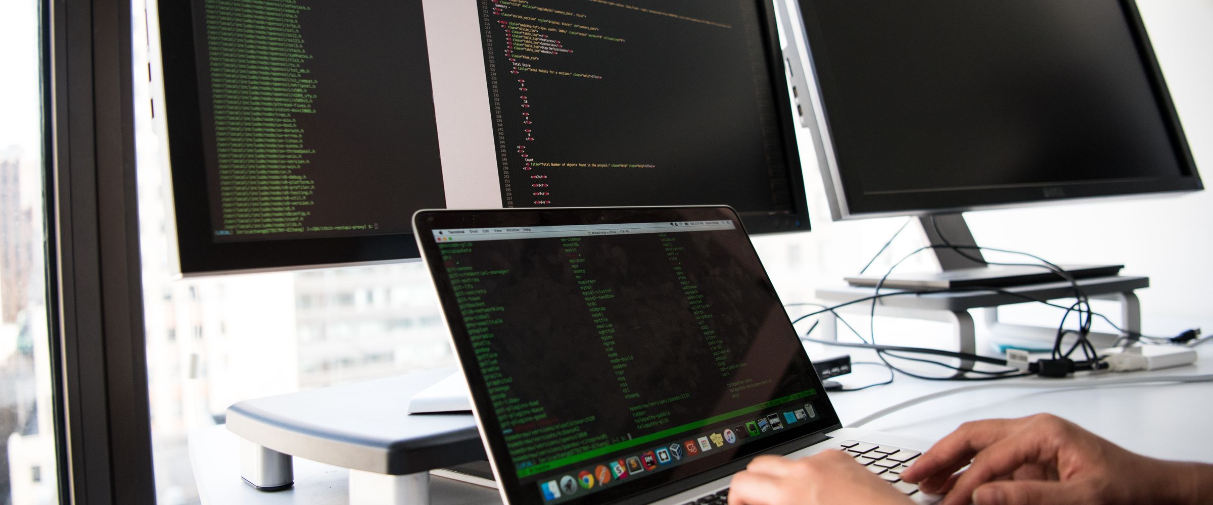 Engineers reviewing a web application across several monitors