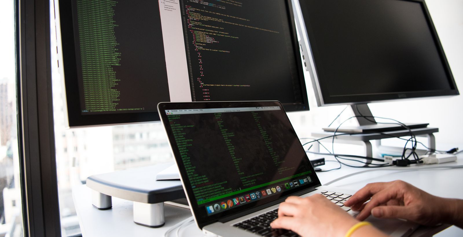 A developer workstation with two monitors showing code
