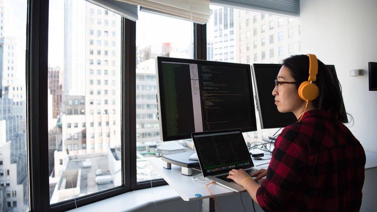 A developer working across multiple monitors while building a workflow