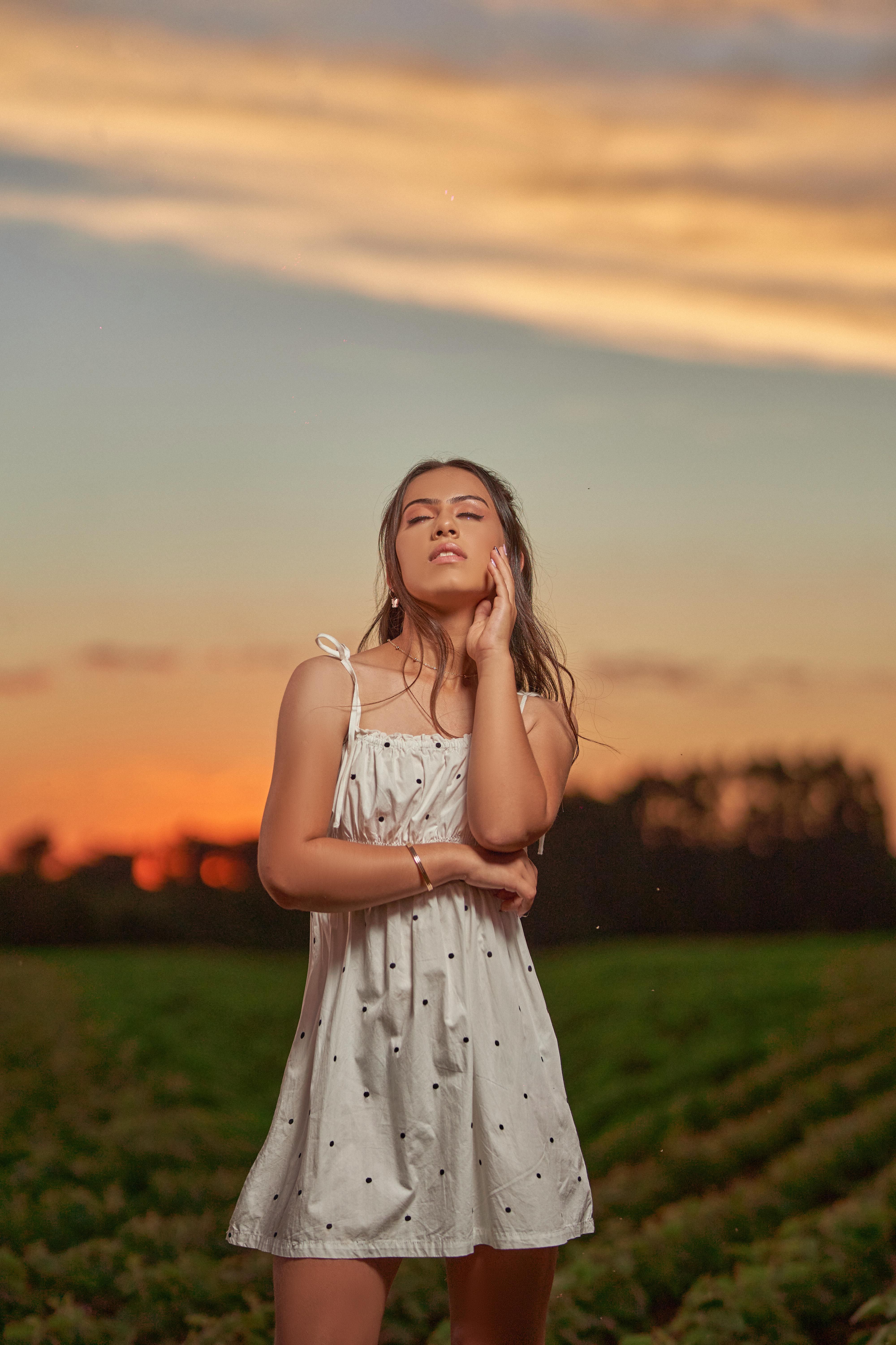 A Woman in White Dress Standing and Posing on Green Grass Field · Free ...