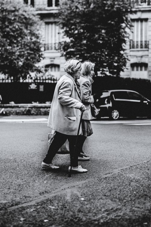 Free Two senior women walk in an urban setting, captured in black and white, emphasizing urban life. Stock Photo