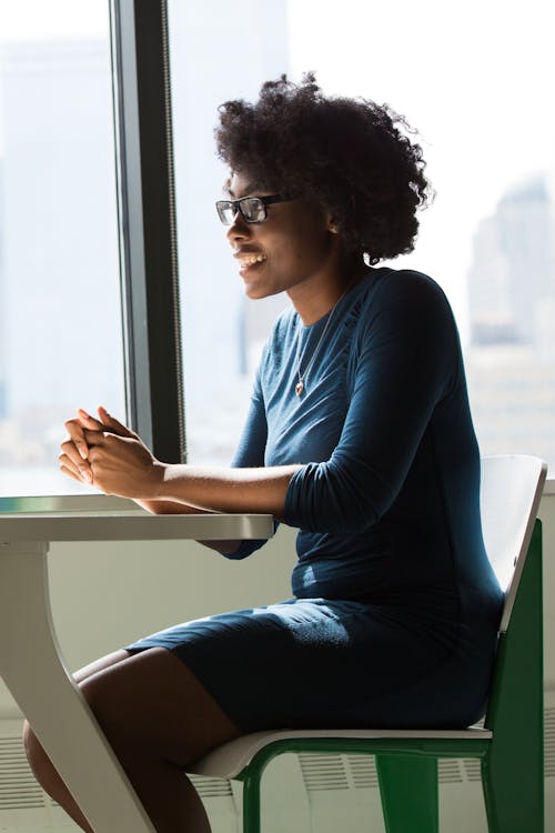 Woman Wearing Eyeglasses Sitting Beside Table and Window