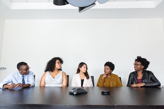 A diverse group of professionals having a meeting in a modern office setting. Teamwork and collaboration.