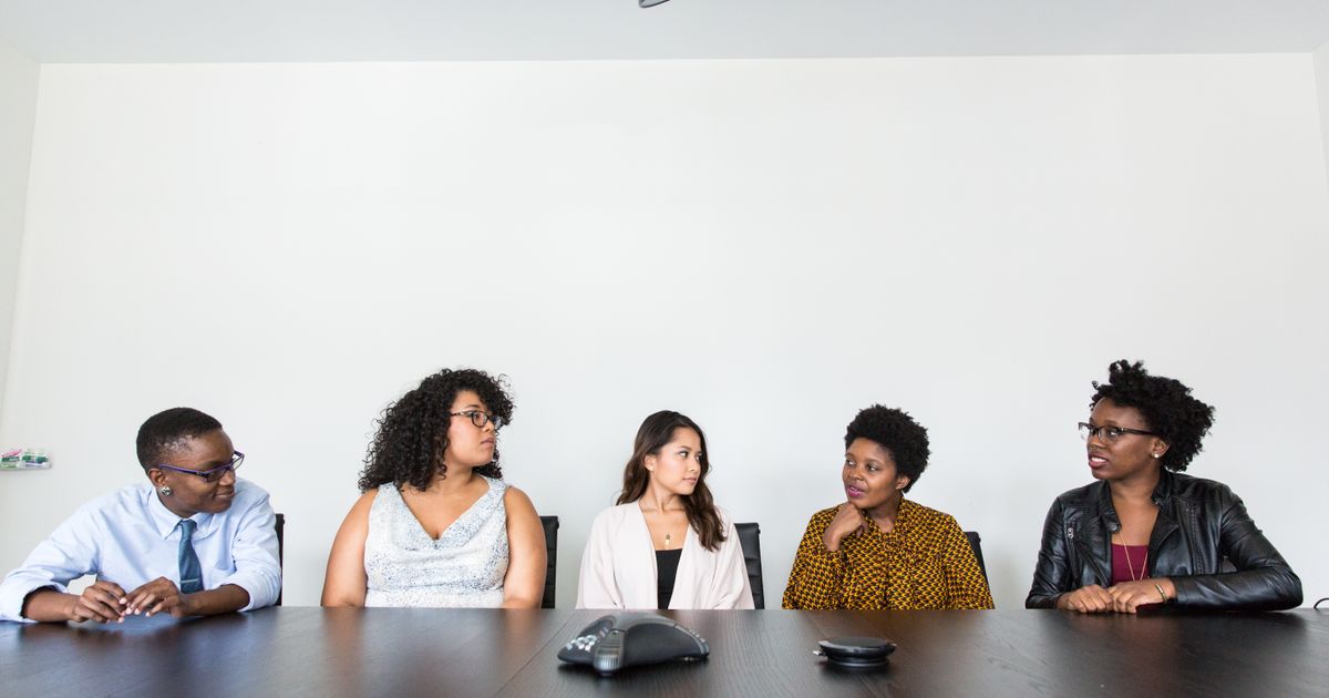 Skilled Worker Visa UK Requirements: Complete 2026 Guide — A diverse group of professionals having a meeting in a modern office setting. Teamwork and collaboration.
