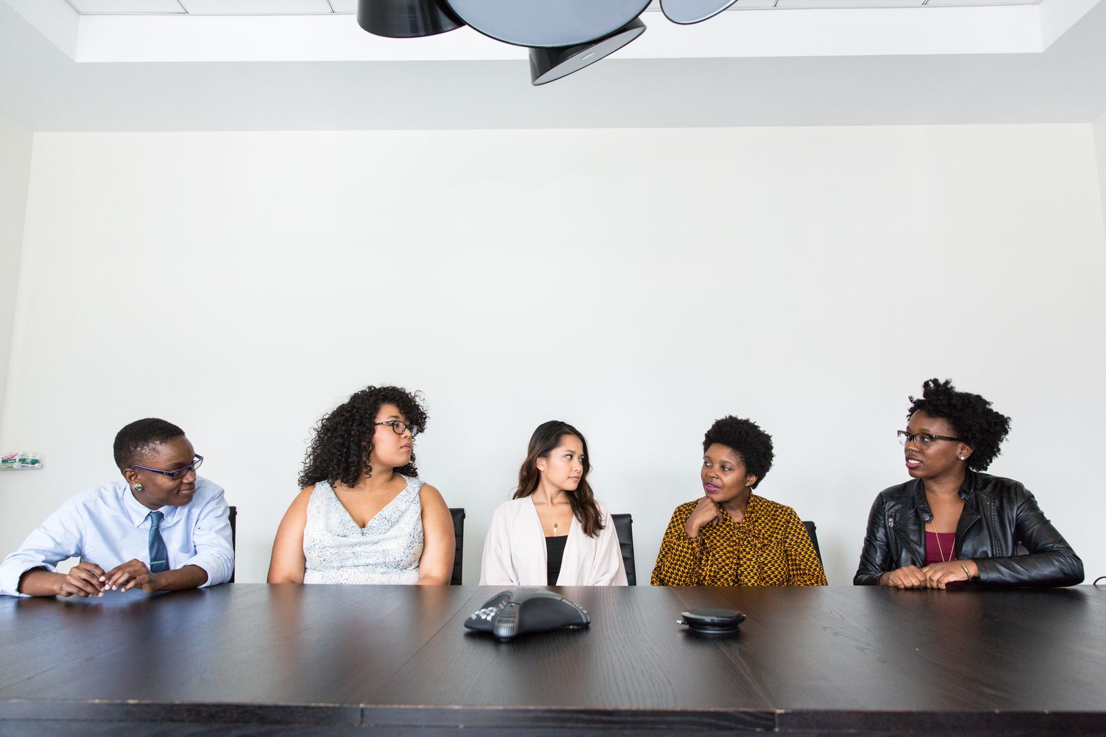 Five people seated together in conversation