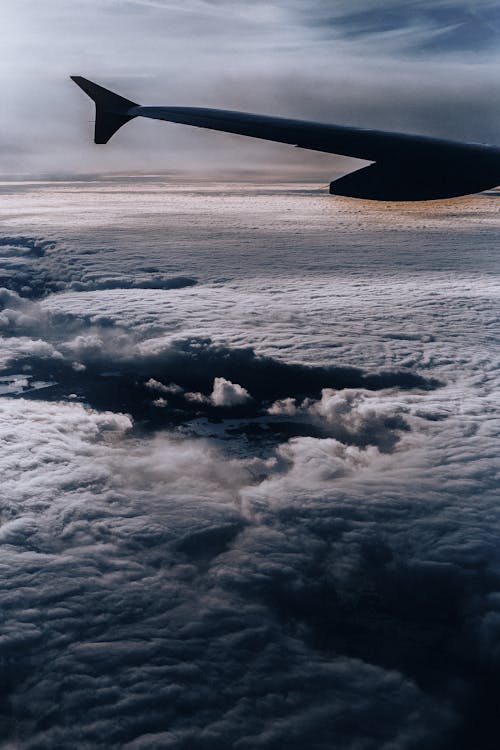 Wing of an Airplane over White Clouds