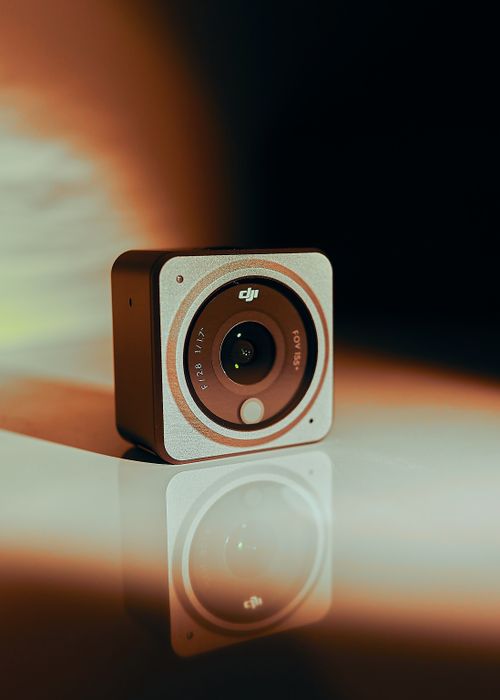 Free Close-up of a compact square camera with a reflective surface and blurred background. Stock Photo