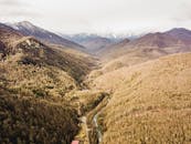 鸟瞰图捕捉到一个郁郁葱葱的山谷，四周环绕着风景秀丽的山脉，令人叹为观止