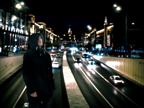 道路の背景と黒のパーカーを着ている男