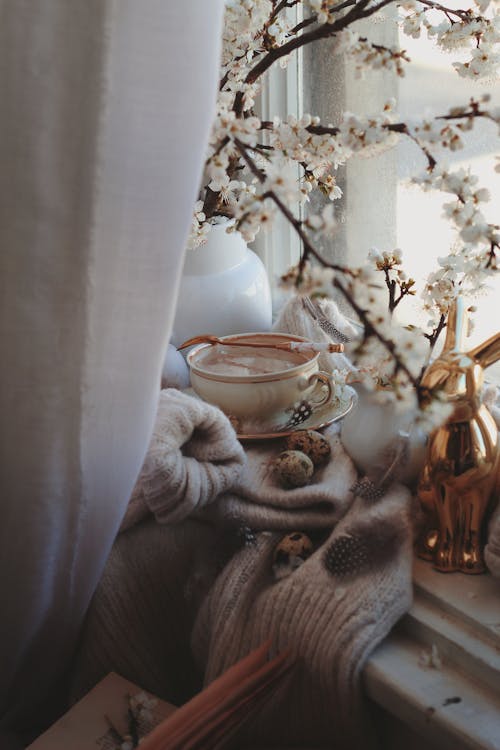 Still Life with Hot Chocolate, Beige Sweater, and Blossoming Tree Branch