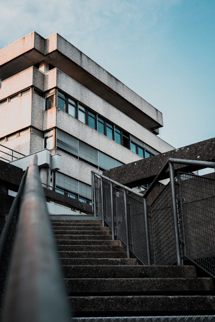 Concrete facade seen from a stairwell — photo by Nici Gottstein on Pexels