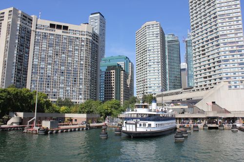 Free A scenic urban skyline with a docked ferry boat against a clear blue sky. Stock Photo
