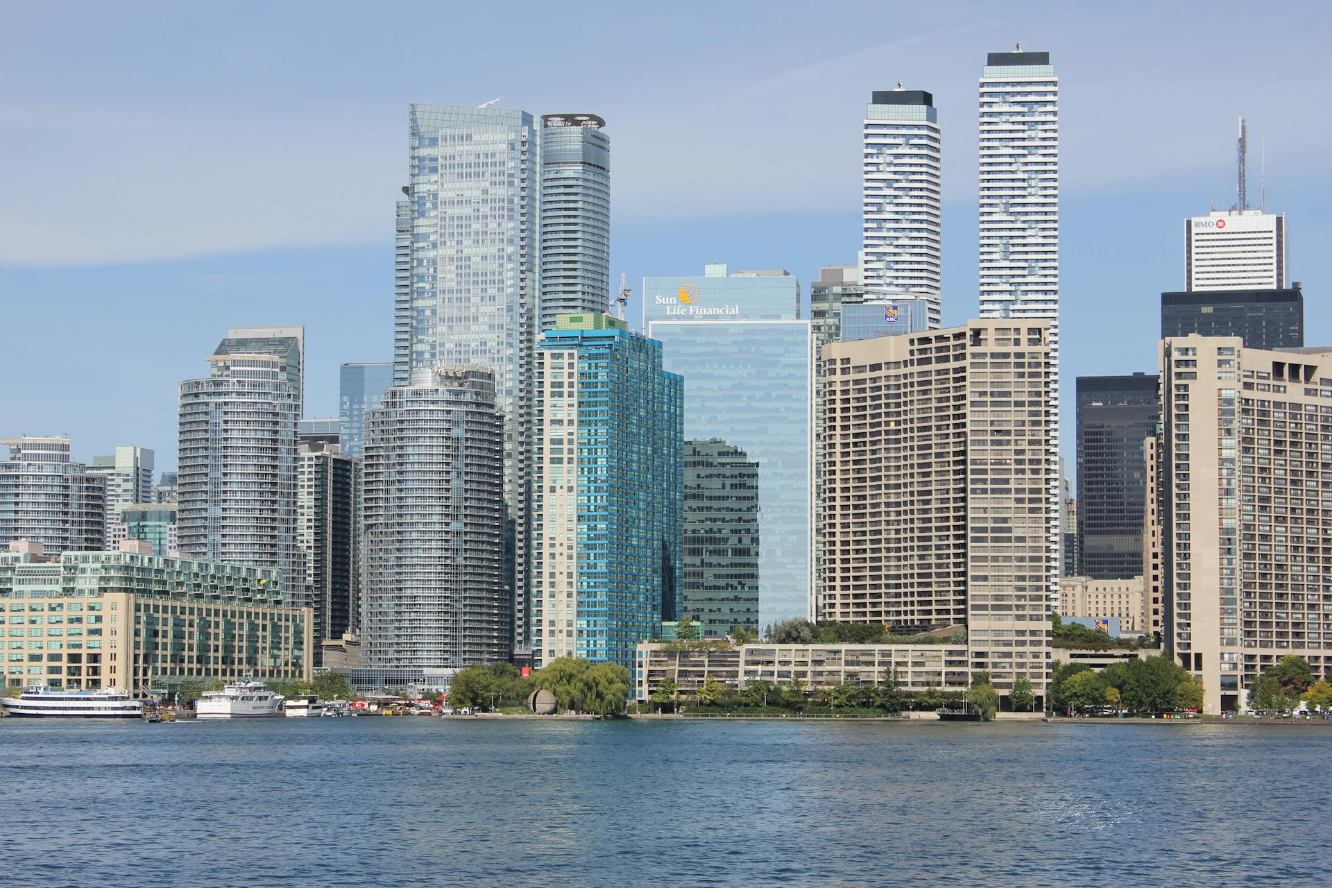 A stunning skyline of Toronto city featuring high-rise buildings across a calm waterfront.