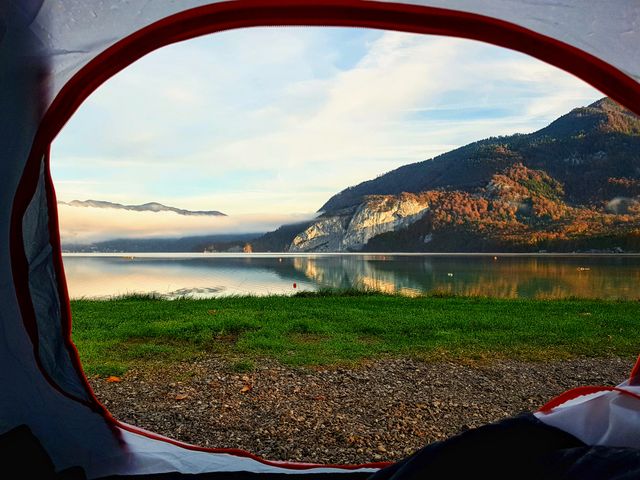 View from a tent doorway across a valley lake at sunrise — photo by Frank J on Pexels