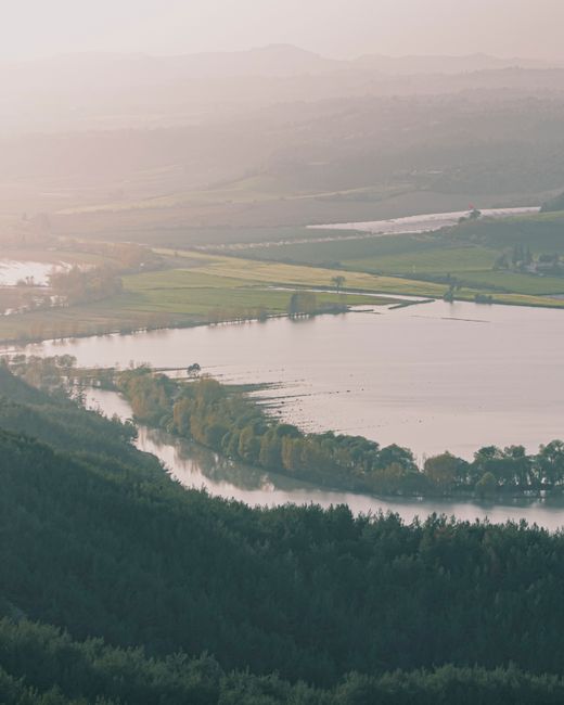 A breathtaking aerial view of a serene lake surrounded by lush greenery and mountains in Adana, Turkey.