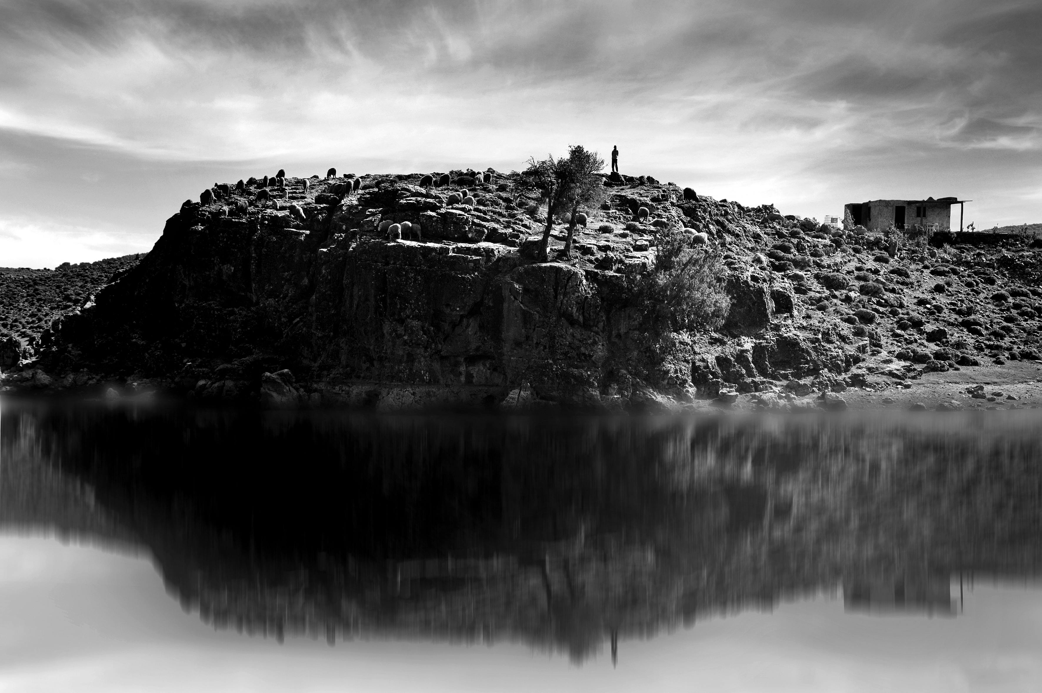 Peaceful black and white landscape of a lakeside cliff in Ifran, Morocco, reflecting tranquility.