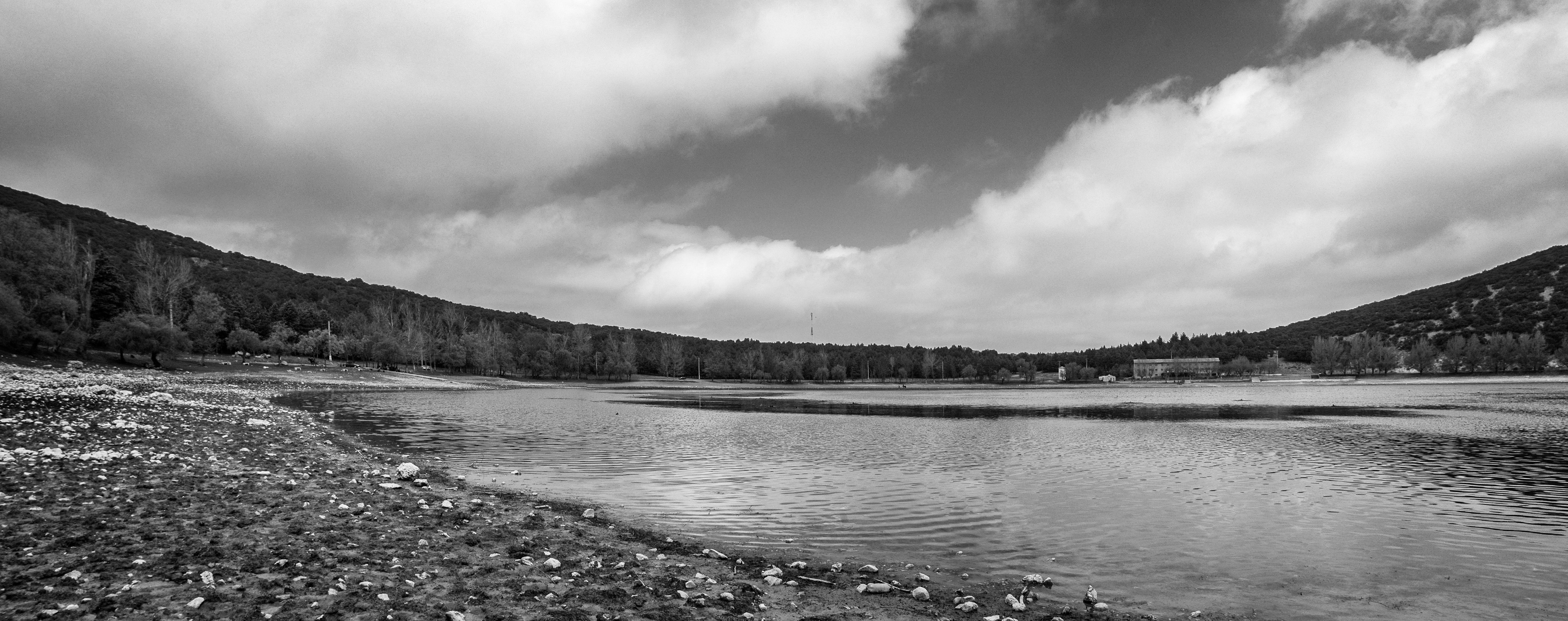 Stunning monochrome panorama of Ifran Lake, surrounded by hills and a cloudy sky. - Ifrane