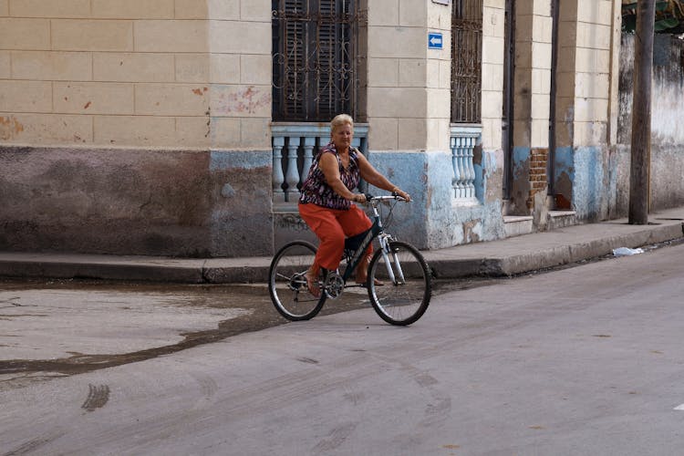 An Elderly Woman Riding A Bike 