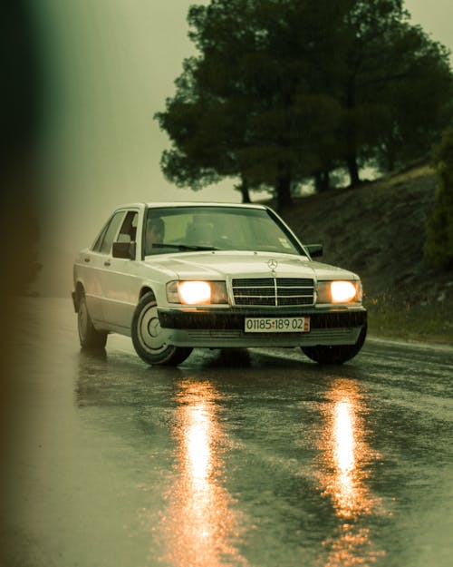 
A White Mercedes Benz Car on a Wet Road