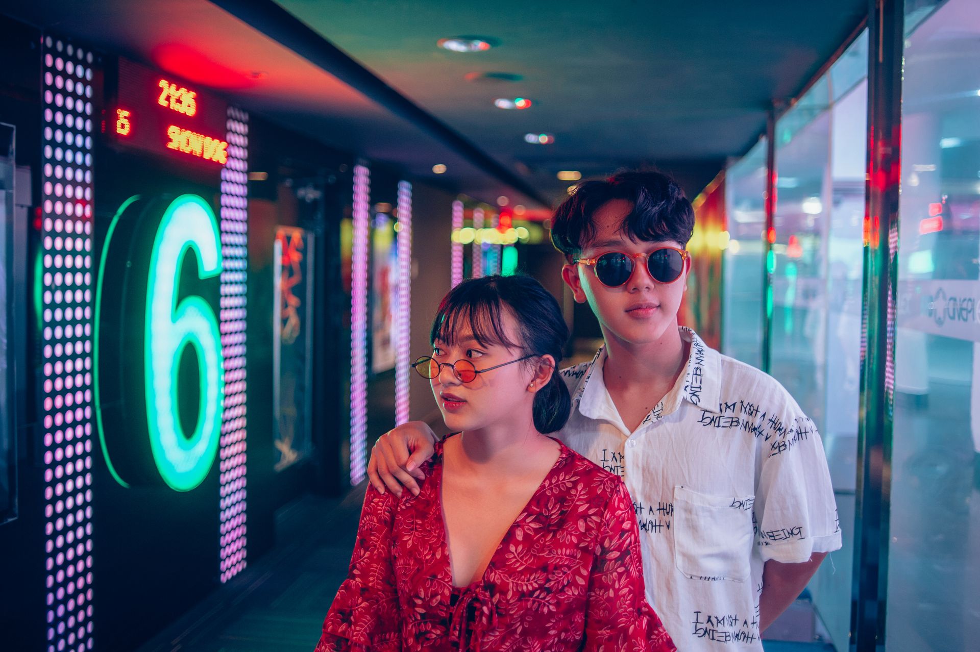 Man and Woman Standing on Hallway Surrounded by Led Lights