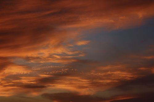 Free A stunning view of a vibrant sunset sky filled with dramatic cloud formations. Stock Photo