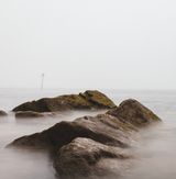 Moss-covered rocks at the waterline, photo by Ellie Burgin on Pexels