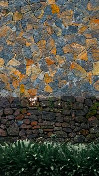 A vibrant stone facade in Mauritius featuring a mosaic of colorful stones and lush greenery.