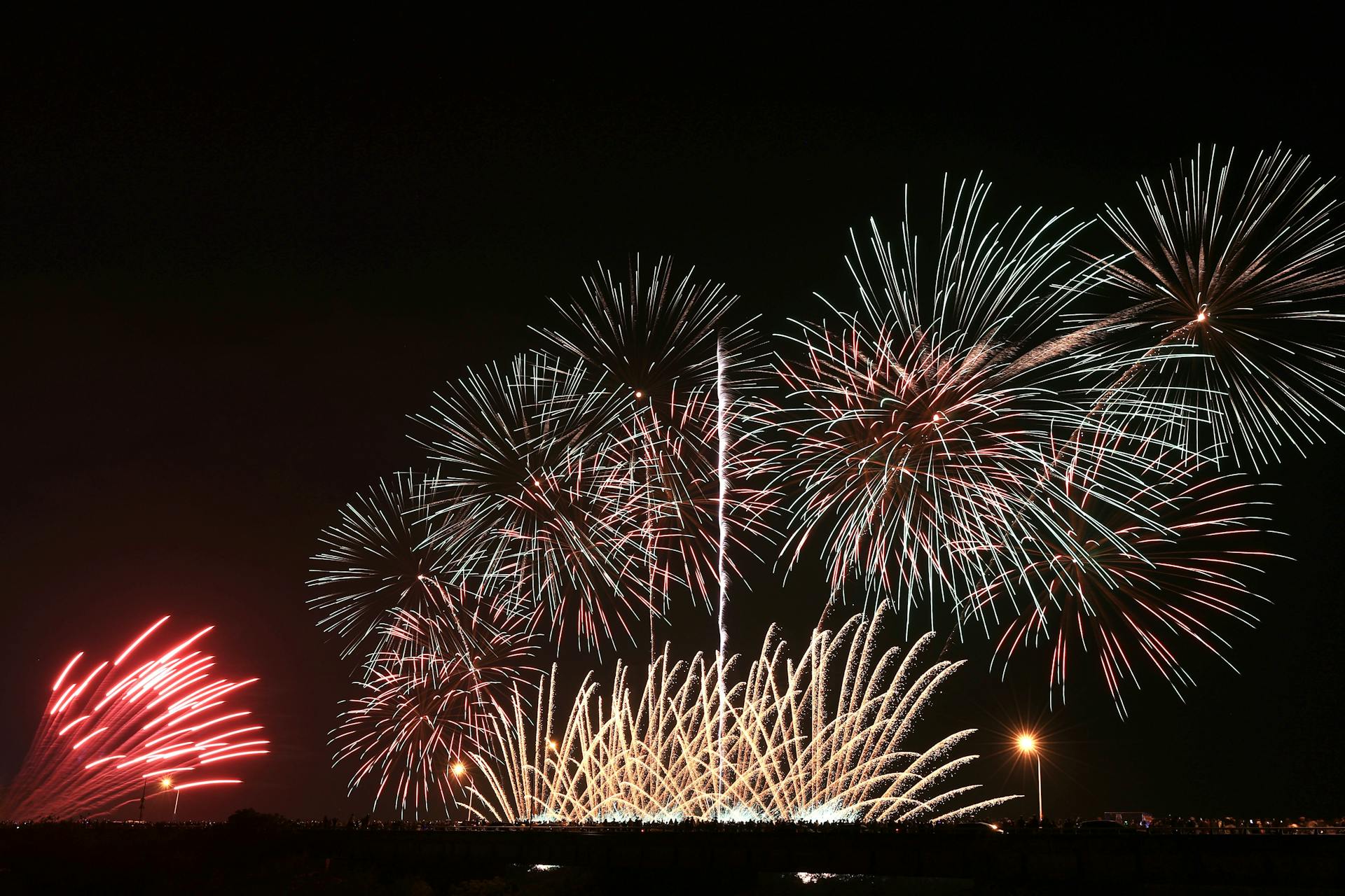 Captivating nighttime fireworks display lighting up the sky with vibrant colorful bursts.