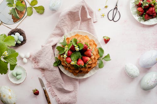 Easter Eggs and a Dessert with Strawberries on a White Tablecloth 