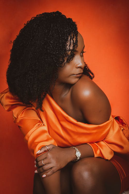 A Woman in Orange Dress Posing