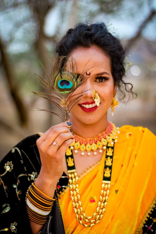 Woman in Traditional Clothing Holding a Feather · Free Stock Photo