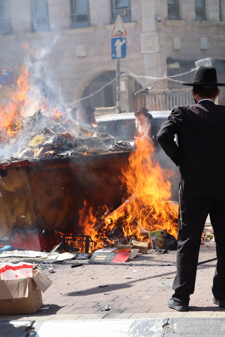 Men Burning Items In A Trash Bin