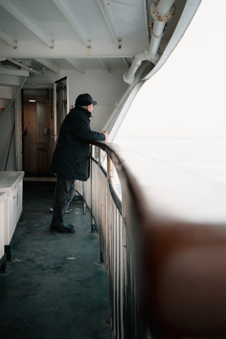 Man Wearing Black Jacket Leaning On Ship Railings