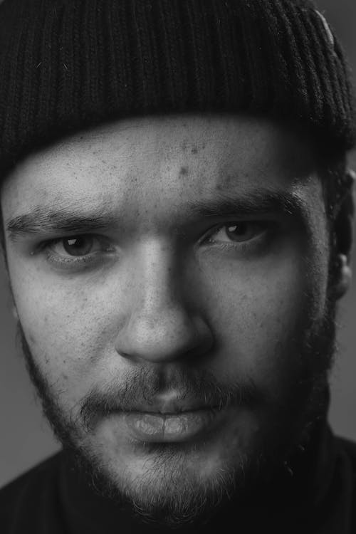 Grayscale Photo of a Man Wearing a Beanie