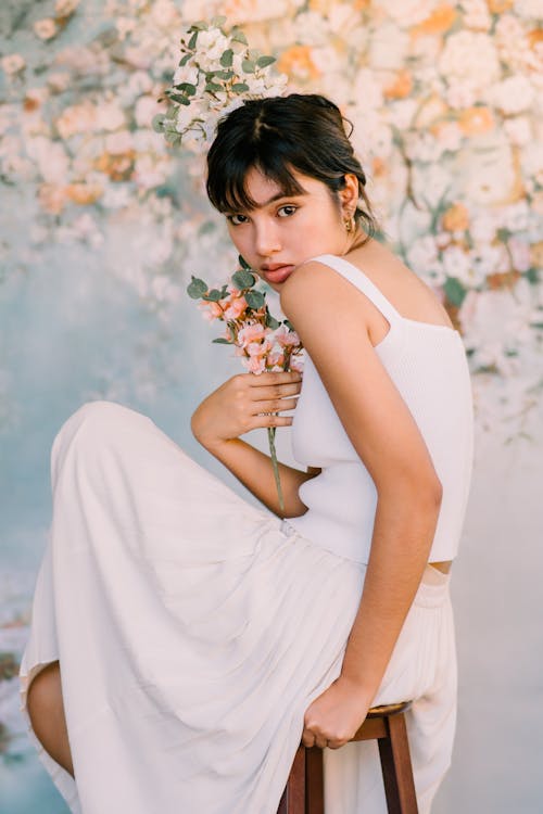 Beautiful Woman in White Clothes Holding Flowers