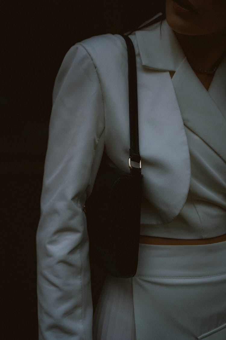 Woman In White Suit With Black Handbag