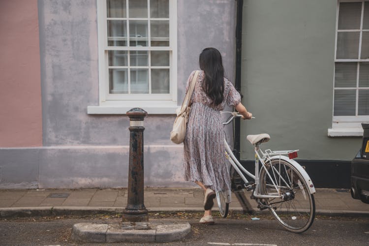 Woman In Long Dress Pushing A Bicycle