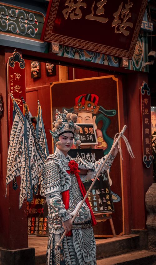 Free Elegant opera performer in traditional attire stands in front of a cultural venue in Chongqing, China. Stock Photo