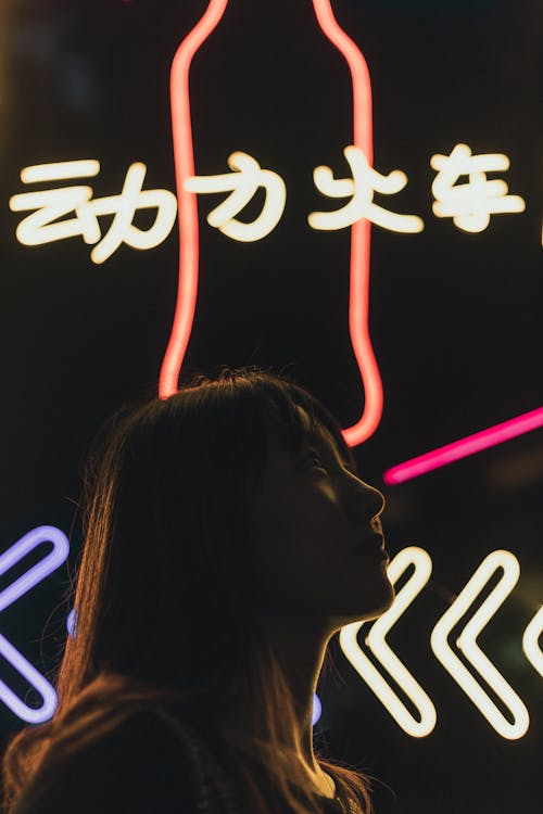 A Pretty Woman Standing in Front of Neon Lights