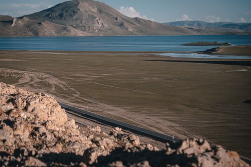 Free Tranquil lake with mountains in Tibet, offering a panoramic and peaceful landscape. Stock Photo